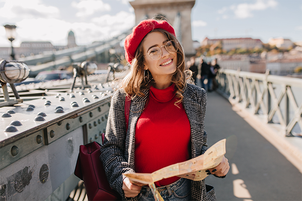 woman-with-red-backpack-posing-bridge